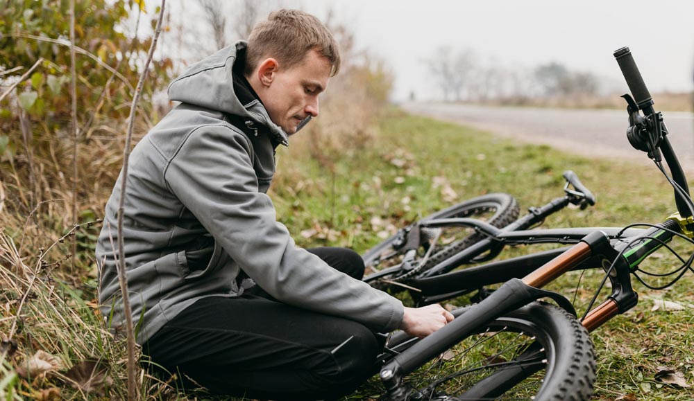 ciclista-revisa-bicicleta-tras-accidente